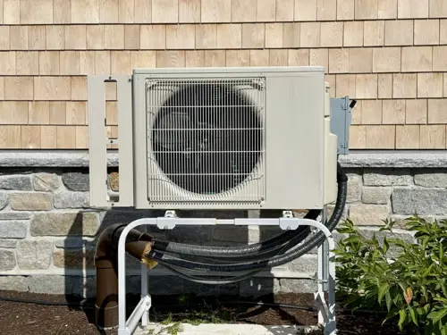 Close-up of building exterior with air heat pump.