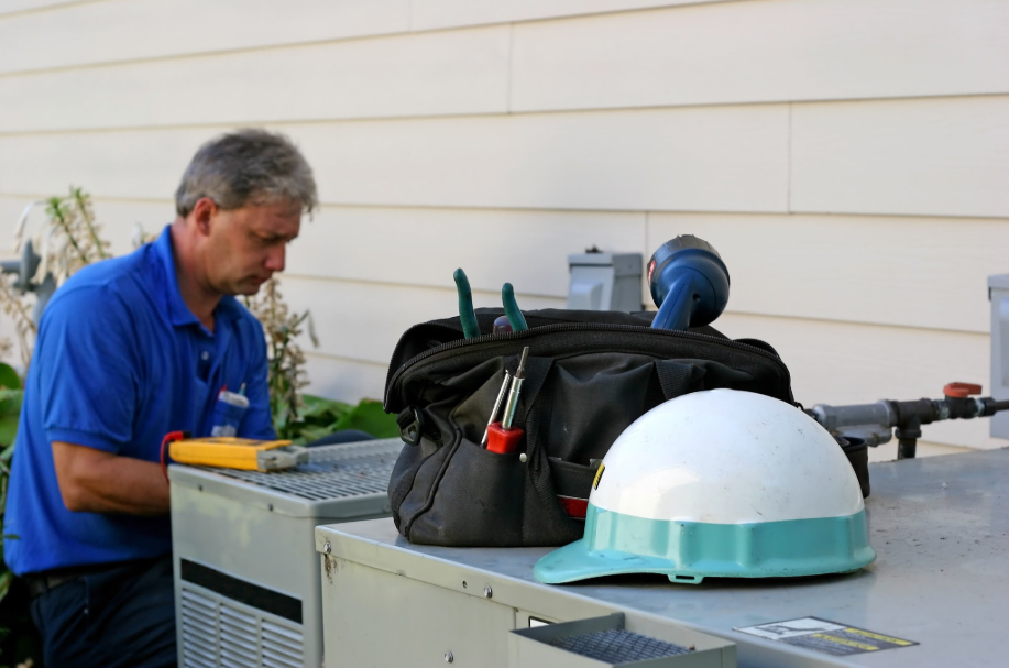 A technician works on outdoor AC units