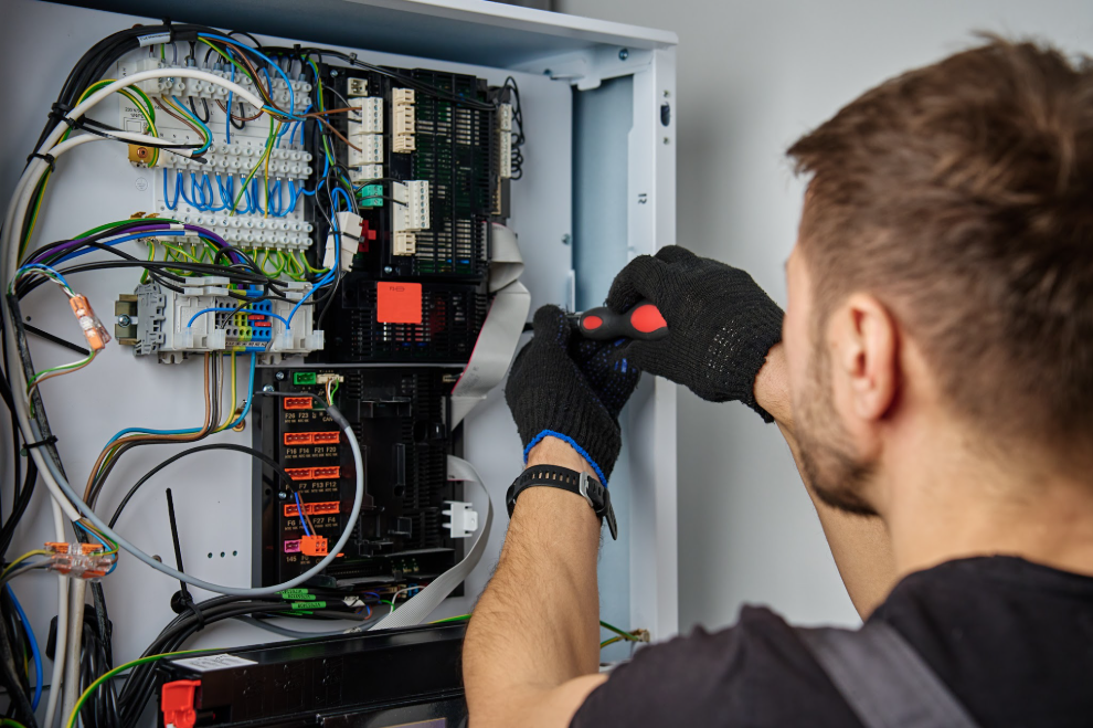An electrician does work on a home fuse box